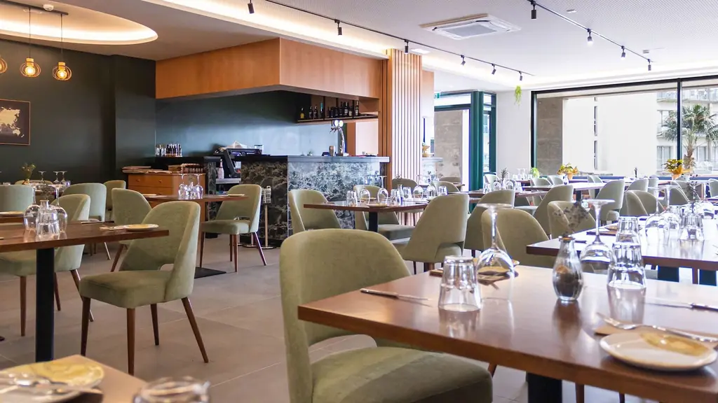 Sala do restaurante Sem Rumo com mesas em madeira e cadeiras verdes